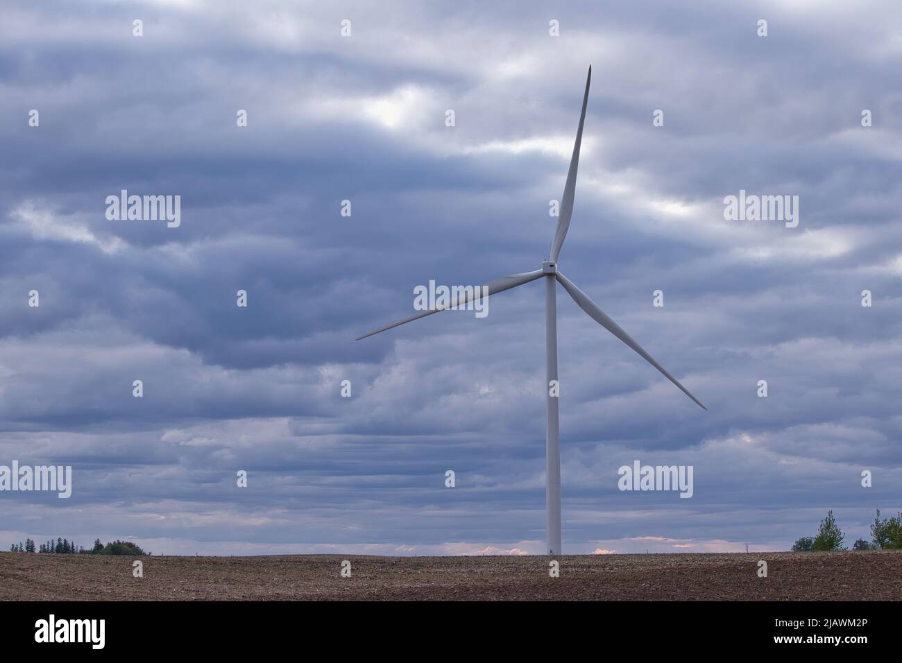 One wind turbine in a farm field with a cloudy sky background Stock ...