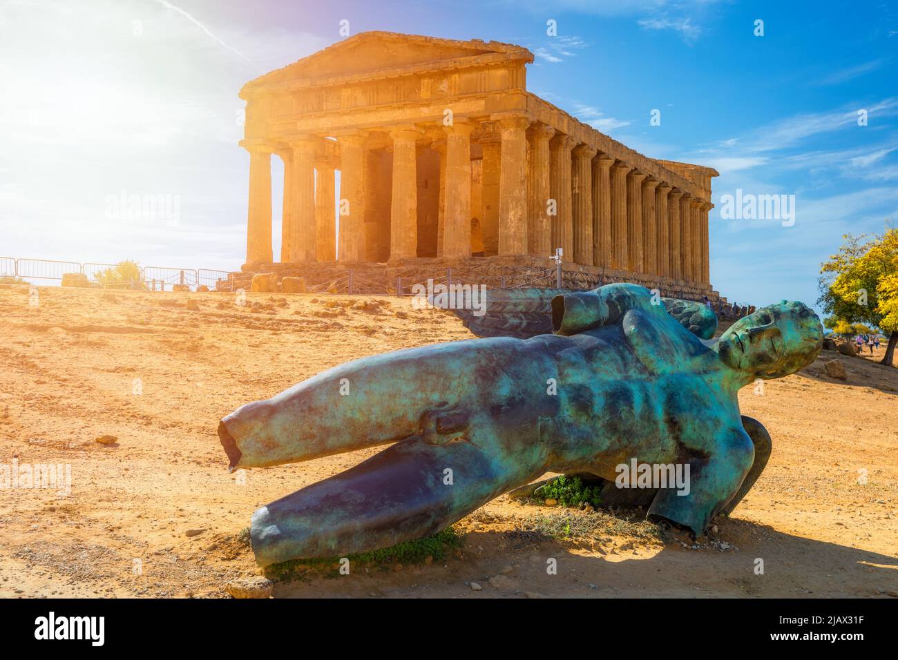 Bronze statue of Icarus in front of the Temple of Concordia at the Valley of the Temples. Temple of Concordia and the statue of Fallen Icarus, in the Stock Photo