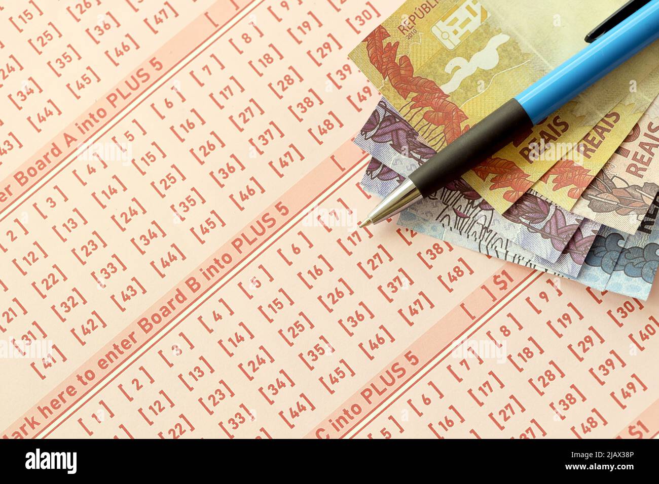Blue pen with Brazilian money bills on blank of lottery game. Concept of  luck and gambling in Brazil Stock Photo - Alamy