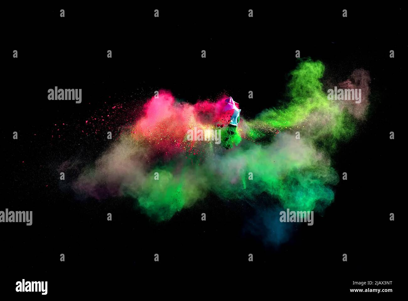 Various multicolored forms of powder paint explode in front of a black ...