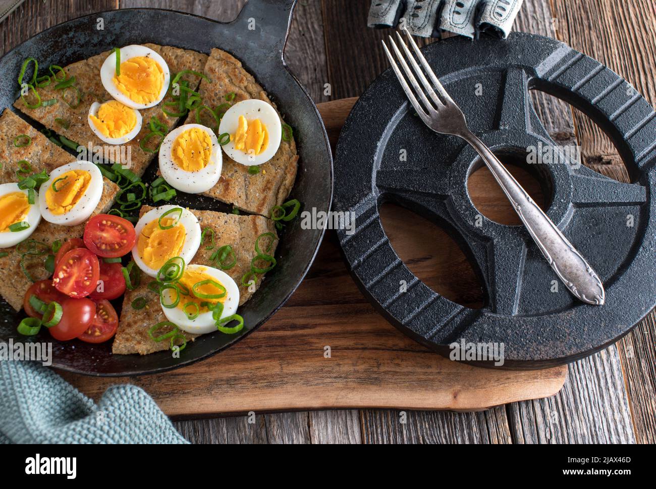 Fitness breakfast with homemade oatmeal pancake, boiled eggs, scallions and tomatoes. Stock Photo