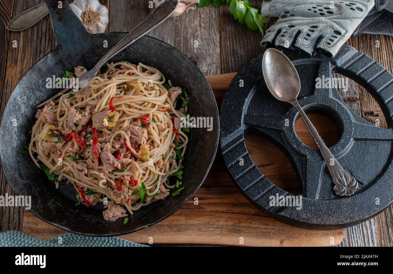 Fitness meal with whole grain spelt pasta, tuna, garlic, olive oil, parsley and chili. 'Spaghetti aglio e olio' Stock Photo