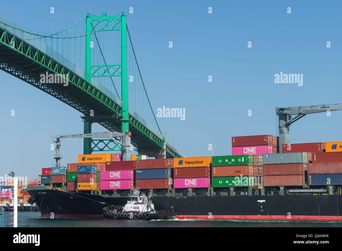 Port of Los Angeles, California, USA - April 27, 2022: image of container ship NYK Joanna shown in transit under the Vincent Thomas Bridge on a sunny Stock Photo