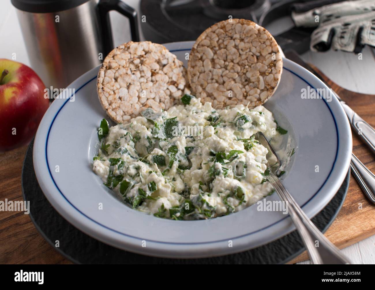 Workout meal with cottage cheese, herbs, olive oil. Served with brown rice cracker on a plate Stock Photo