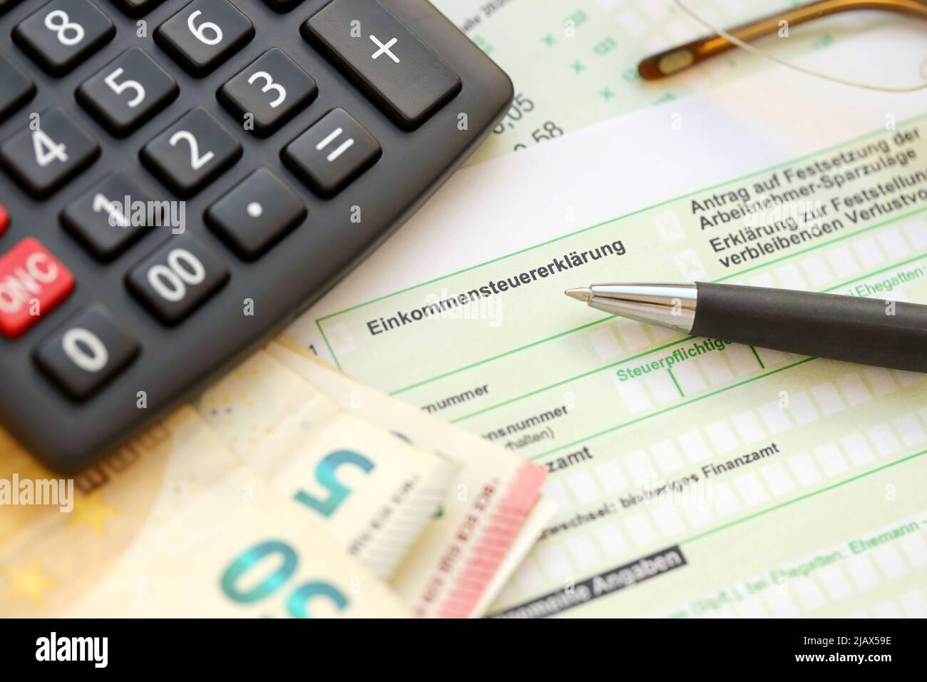 German income tax return form with pen and european euro money bills lies  on accountant table close up. Taxpayers in Germany using euro currency as  ma Stock Photo - Alamy