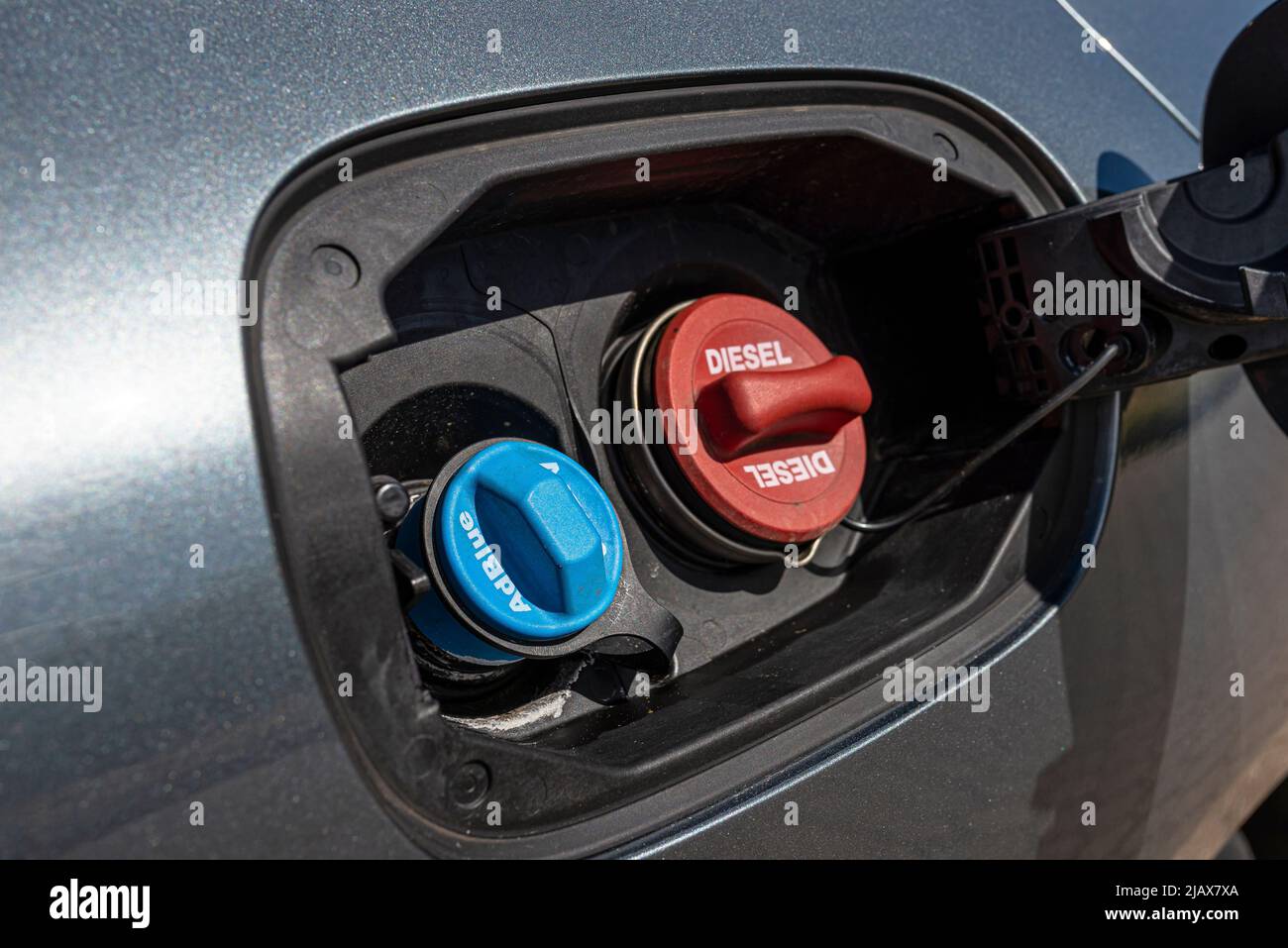 Fuel filler flap open with red diesel cap and blue adblue, the fuel