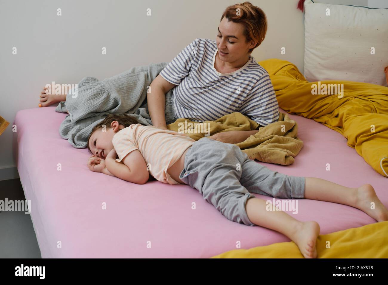 Mother having fun with son on bed. Mom and toddler playing, tickling a child,  laughing in the morning. Positive emotions after sleep. Awaking kid Stock  Photo - Alamy