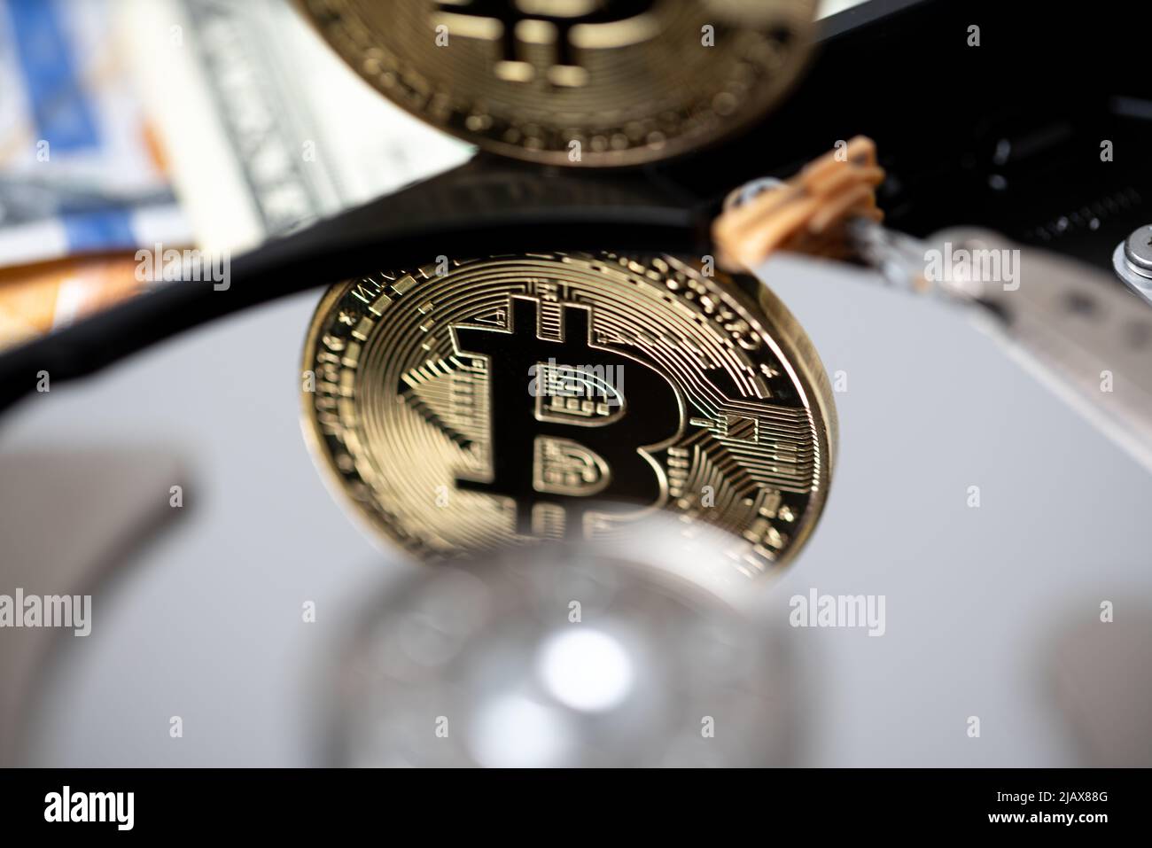 Bitcoin reflecting on hard drive platter. Crypto currency mining concept, block chain technology and ledger storing concept. Stock Photo