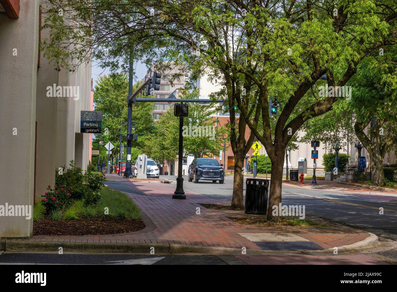 Durham, North Carolina, USA - May 2, 2022:  Trees offer shade on a  street and sidewalk downtown. Stock Photo
