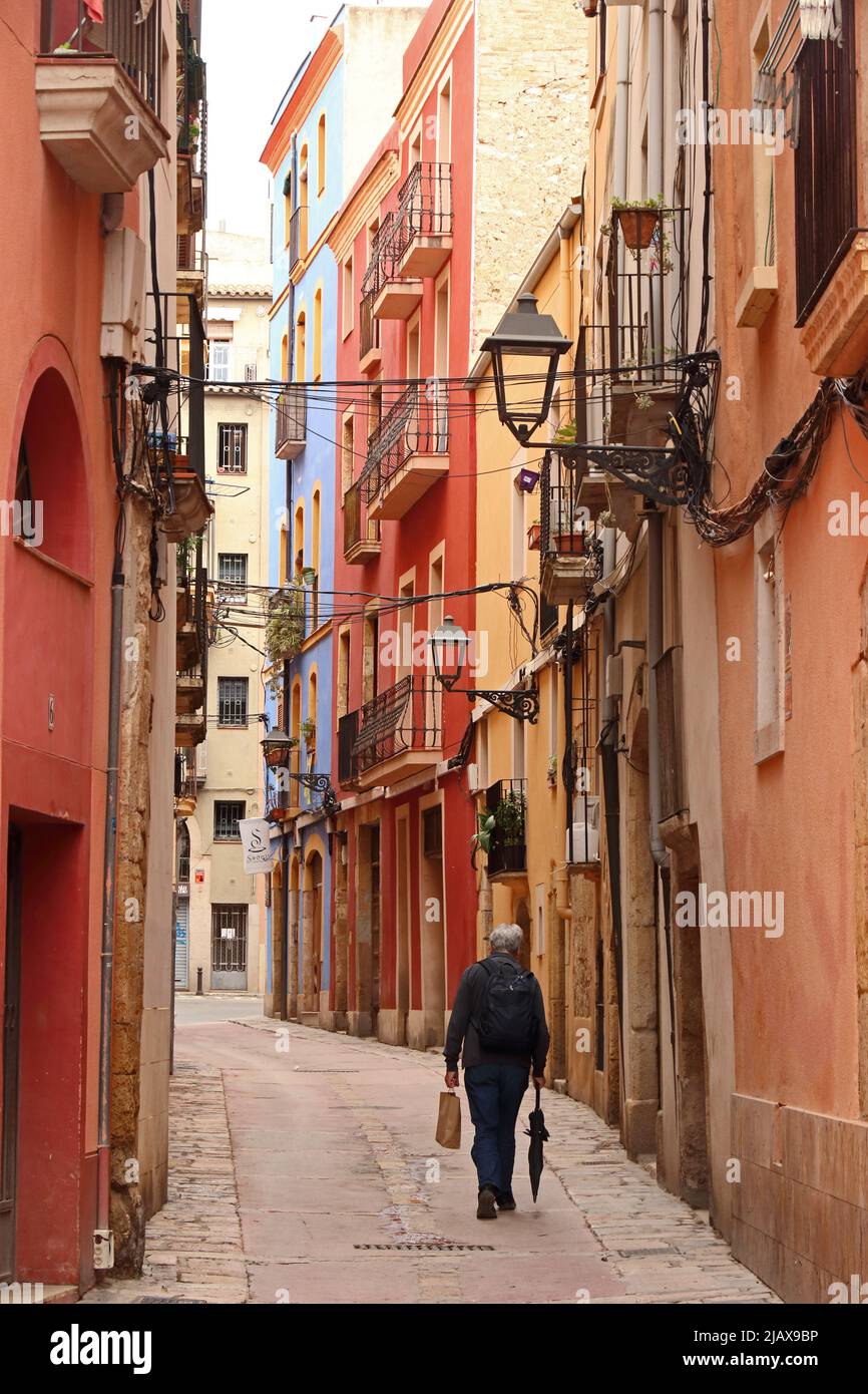 man walking down quiet backstreet in old area of Tarragona Stock Photo