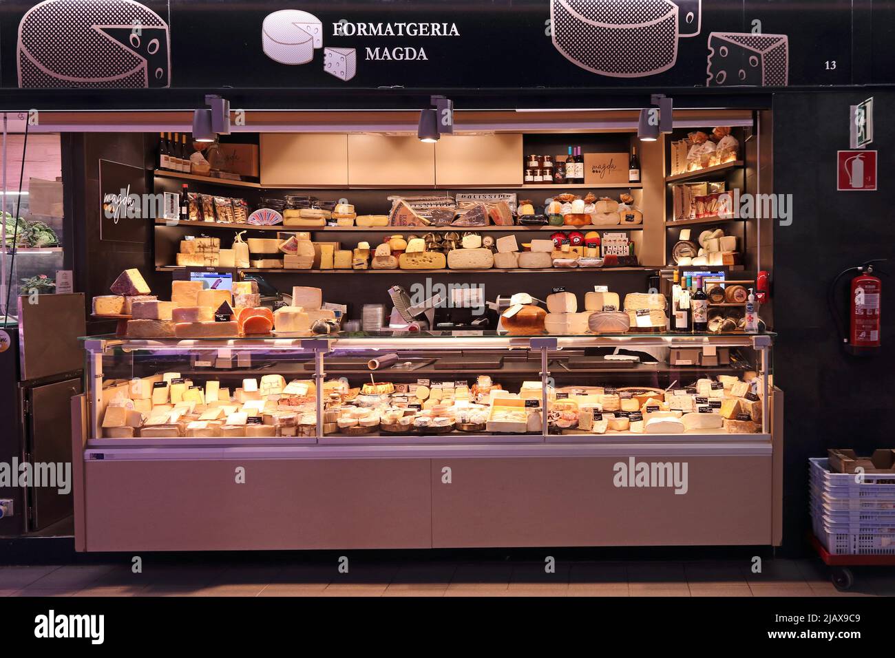 Display of cheeses on sale on stall in market hall, Tarragona Stock Photo