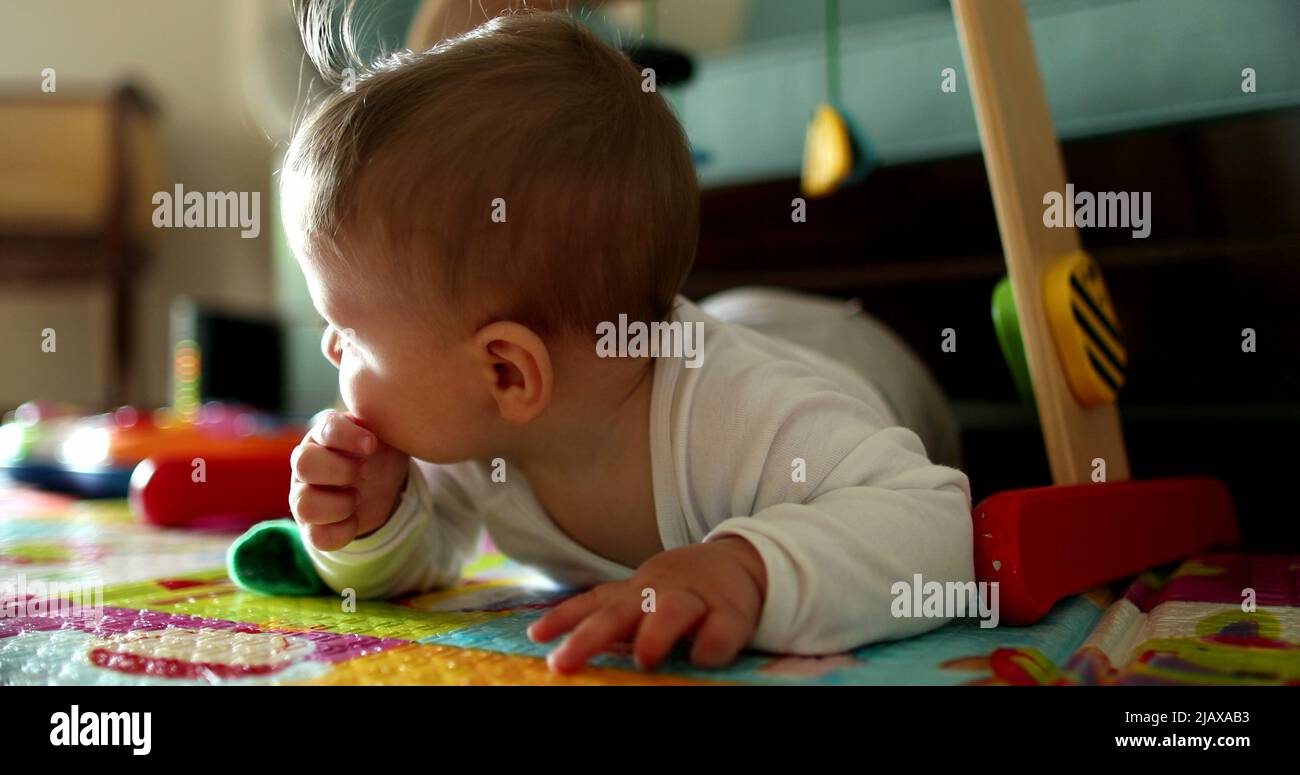 Cute baby infant child development learning to crawl on play mat at