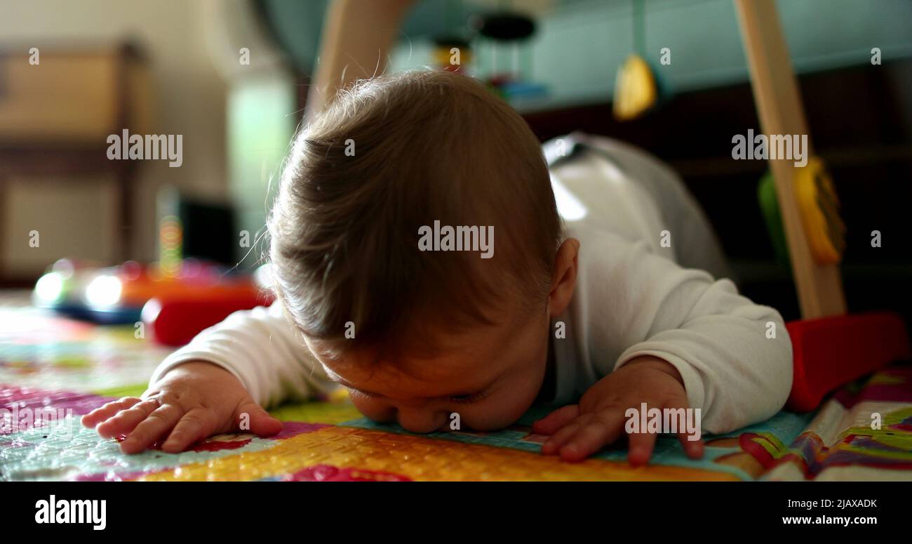 Cute baby infant child development learning to crawl on play mat at