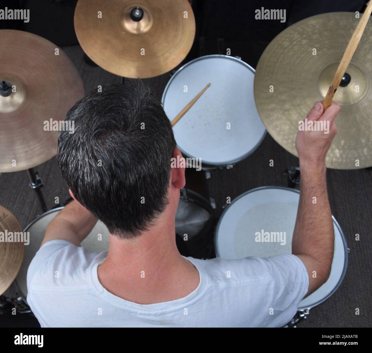 A professional drummer plays drum kit, showing elevated overview action