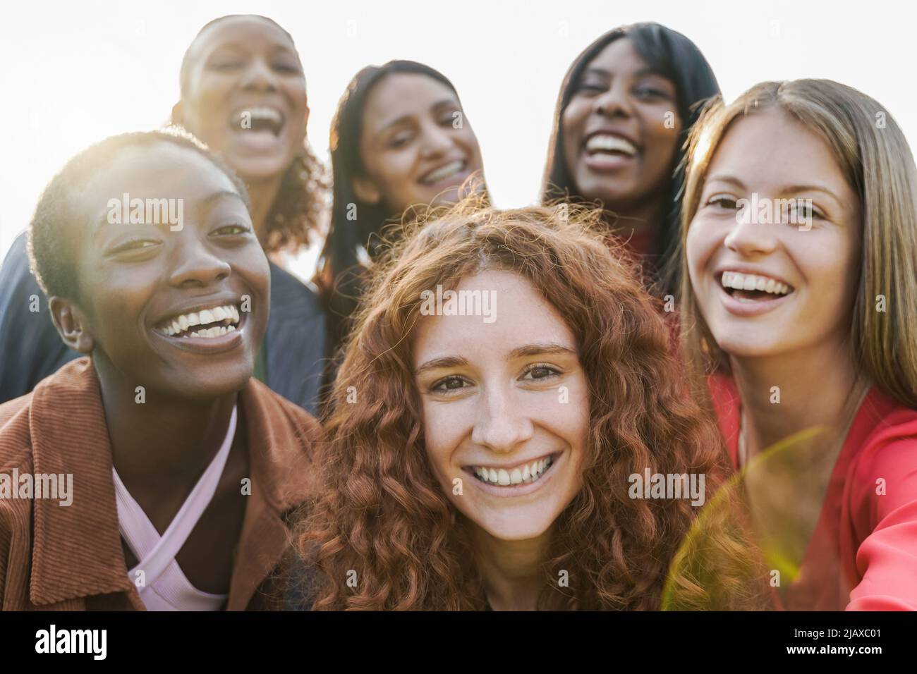 Multiethnic young women having fun together doing selfie outdoor - Focus on ginger hair girl face - Diversity lifestyle concept Stock Photo