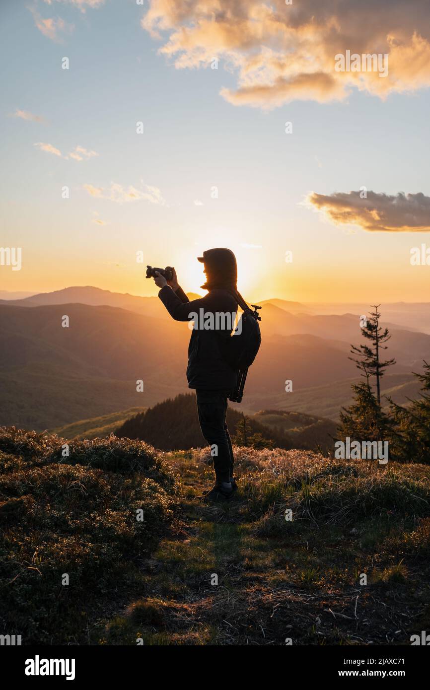 Silhouette of Man Holding Camera at Sunset on the Mountain Stock Photo ...