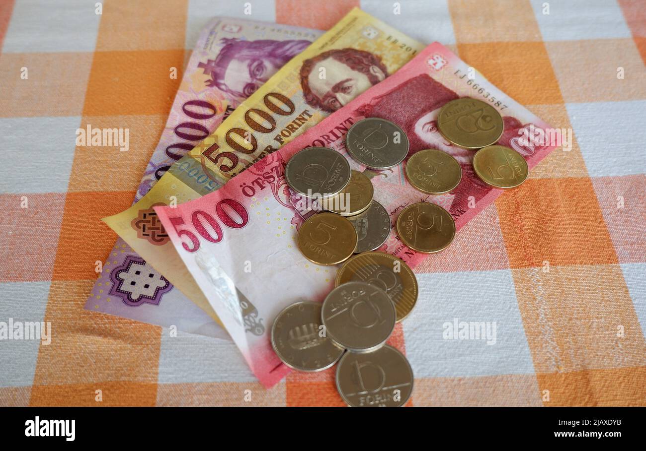 Budapest, Hungary - May 26, 2022: Hungarian forint banknotes and coins on a red white checkered table in a Hungarian home Stock Photo