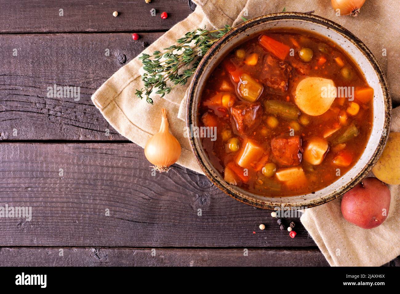 Homemade beef vegetable soup. Top down view table scene on a dark wood background with copy space. Stock Photo