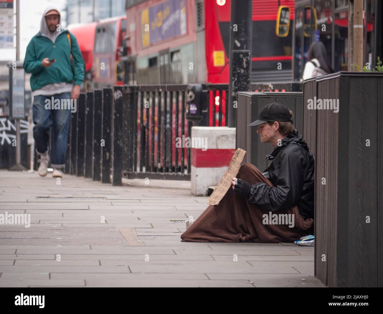 Poverty in London, beggar on London Bridge with blanket and sign Stock Photo