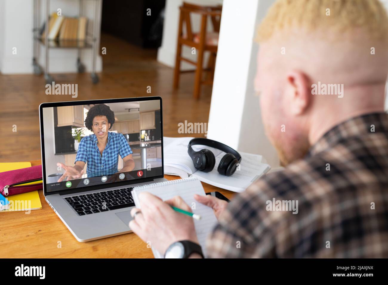 Albino african american businessman noting during video call with ...