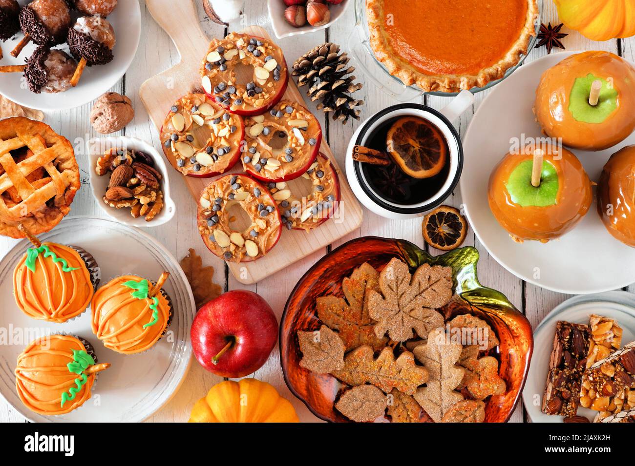Autumn desserts table scene with various sweet fall treats. Top view over a white wood background. Stock Photo