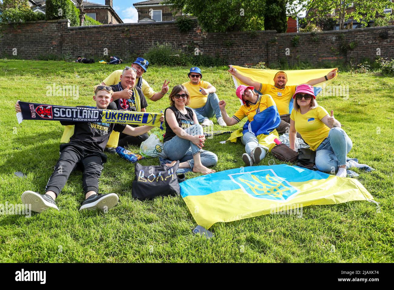 Glasgow, UK. 01st June, 2022. As Hampden Park, the national football stadium of Scotland, prepares for the FIFA world cup play-off semi-final between Scotland and Ukraine, the Ukrainian supporters arrive early and prepare for the game with picnics on nearby grassy areas and communal singing of the Ukrainian national anthem. Credit: Findlay/Alamy Live News Stock Photo