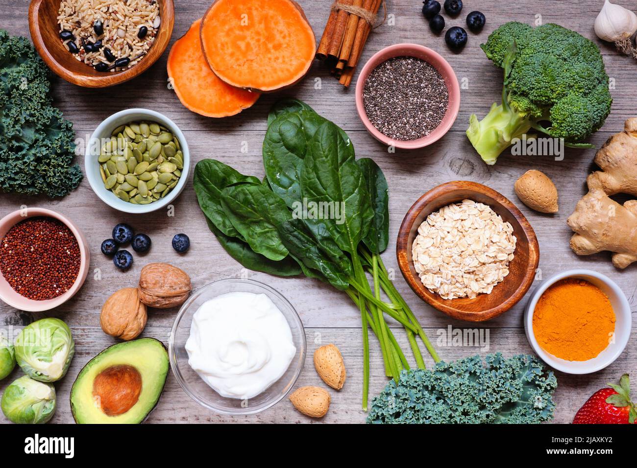 Group of healthy food ingredients. Overhead view table scene on a wooden background. Super food concept with green vegetables, berries, whole grains, Stock Photo