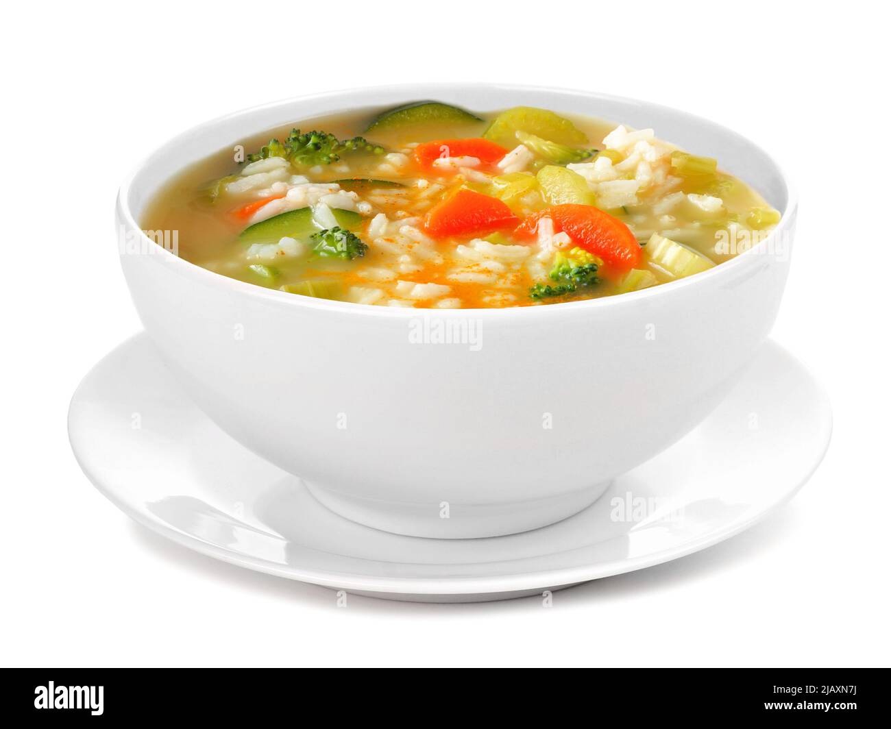 Healthy vegetable soup with rice in a white bowl with saucer. Side view isolated on a white background. Stock Photo