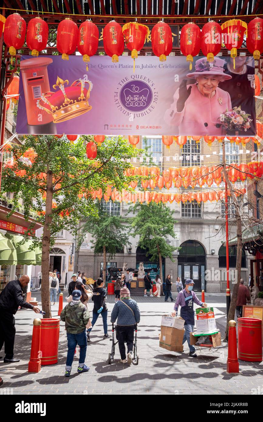 Days before the Queen's Platinum Jubilee celebrations commence over the Bank Holiday acros the UK, a banner showing her face hangs among Chinese lanterns on Garrard Street in the heart of the capital's Chinatown, on 1st June 2022 in London, England. Queen Elizabeth II has been on the UK throne for 70 years, the longest-serving monarch in English history and Union Jack flags can be seen everywhere around the country in the week before the Jubilee weekend. Stock Photo