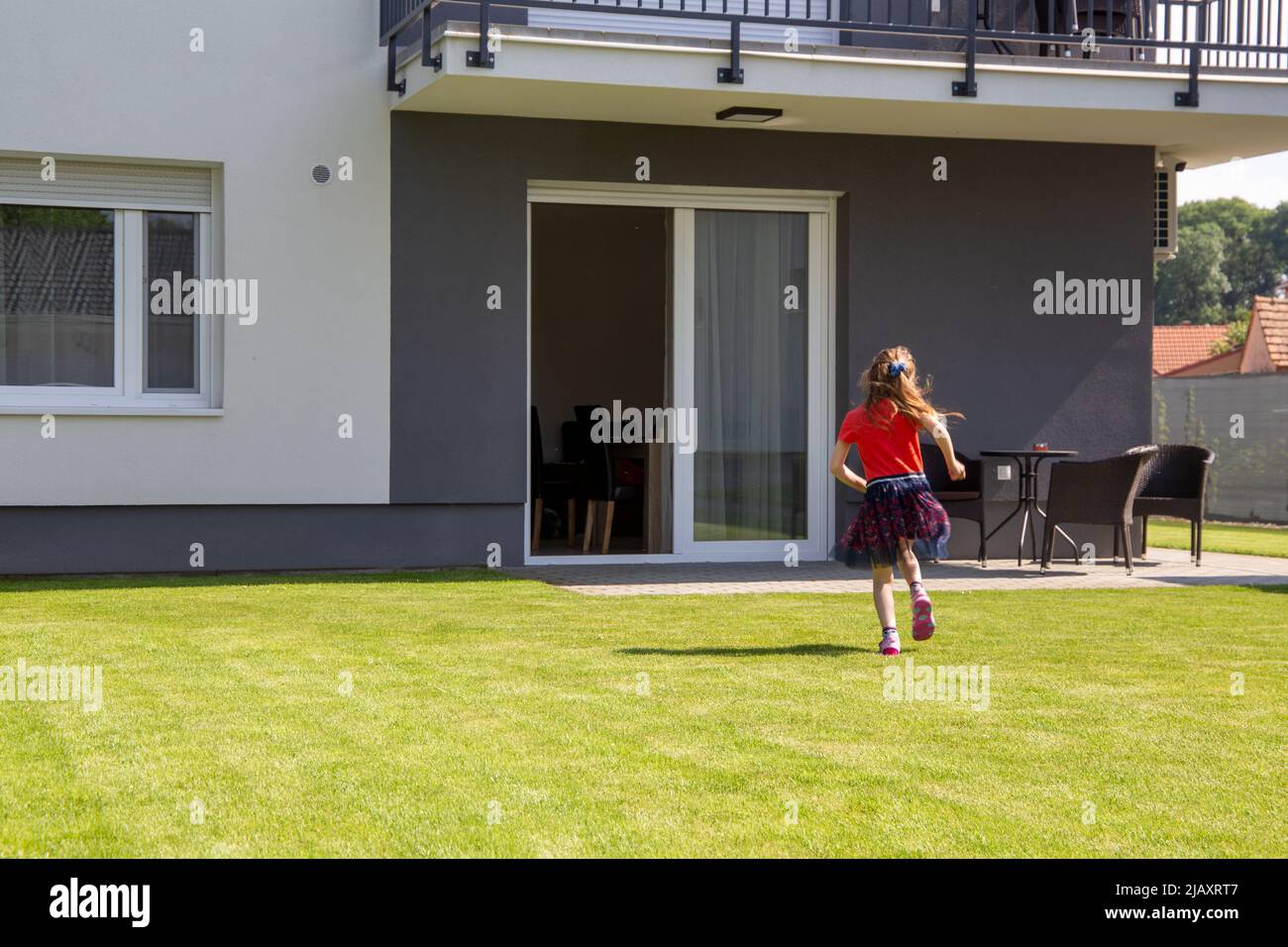 Symbol picture Living and family idyll: Girl in the garden of a newly built detached house (model released) Stock Photo