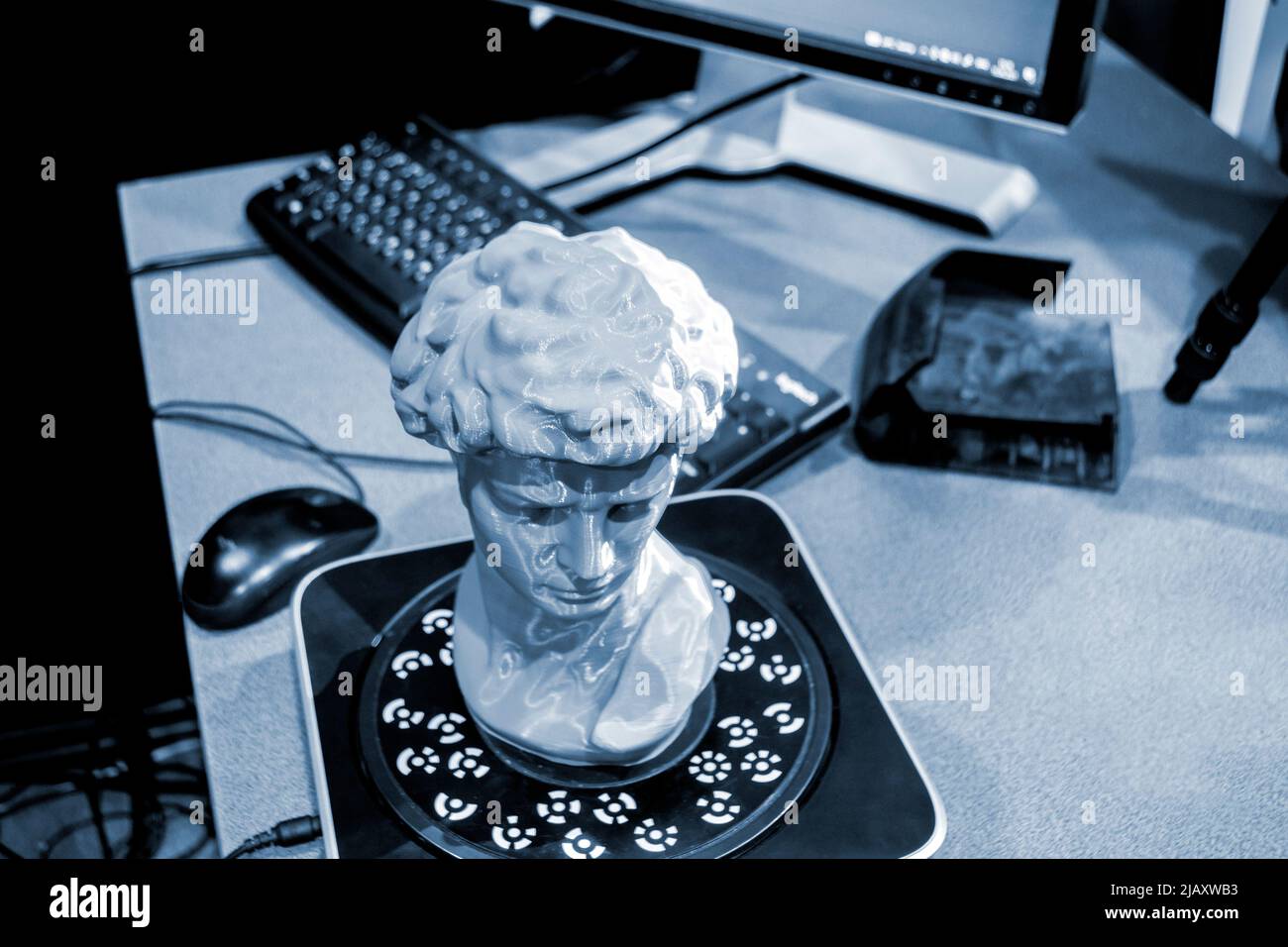 Gray human head on 3d printed close-up. An object prototype of a human head with hair printed by a 3D printer stands on a table. New modern additive 3D printing technology. Fused deposition modeling Stock Photo