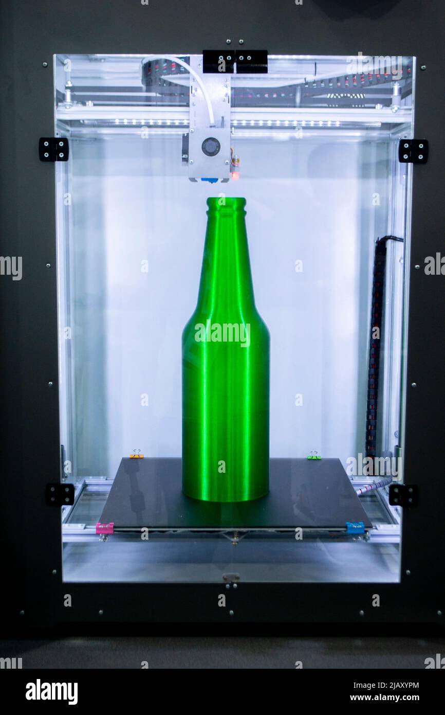 Object green bottle printed on 3D printer close-up, inside on desktop ...