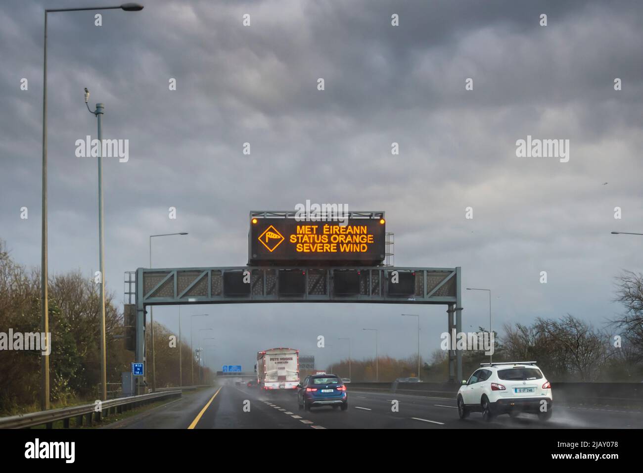 Met Eireann weather warning sign over motorway warns drivers of expected stormy wind on the road. M50, Dublin. Ireland. Stock Photo