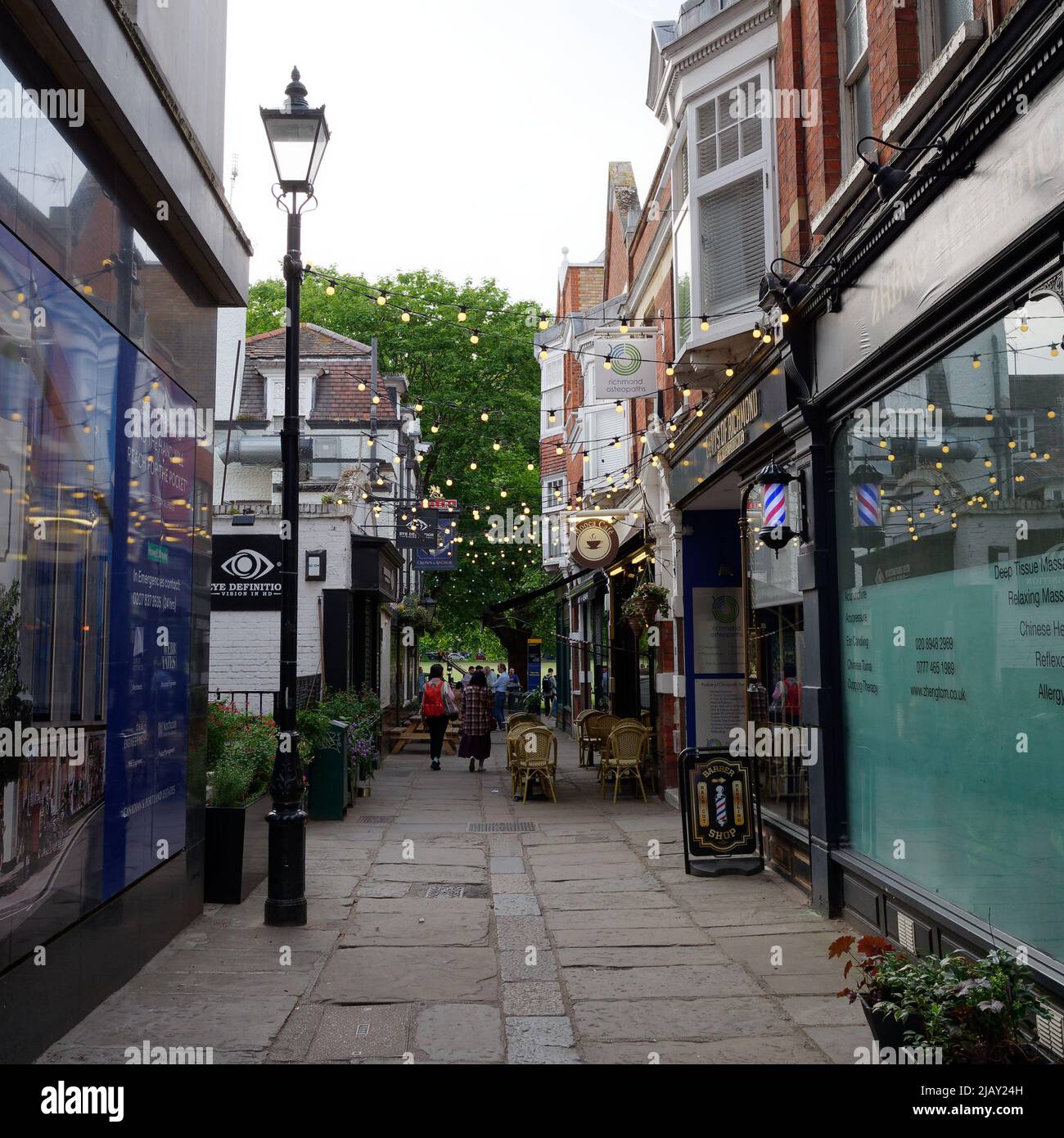 Richmond, Greater London, England, May 18 2022: Looking along a parade of shops and cafes with outdoor seating toward Richmond Green. Stock Photo