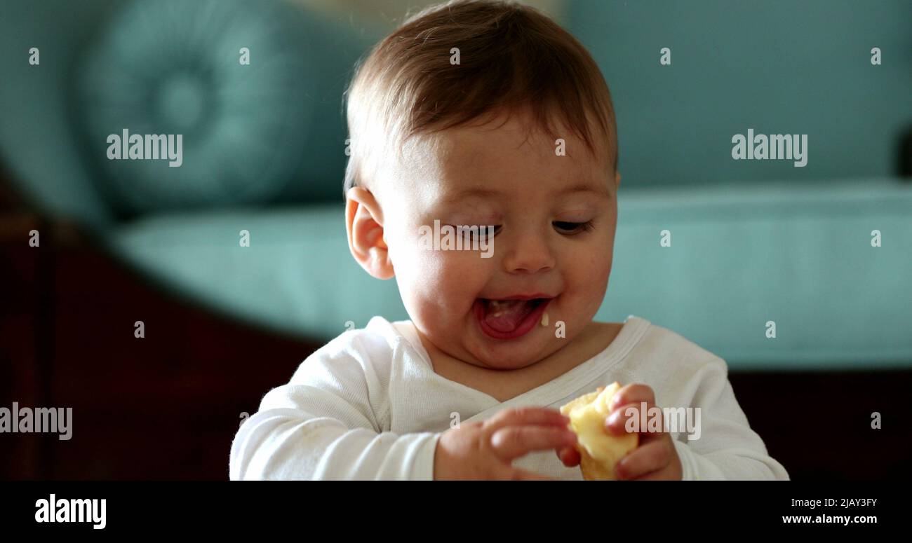 Cute happy baby eating apple fruit snack, infant smiling and laughing Stock Photo Alamy