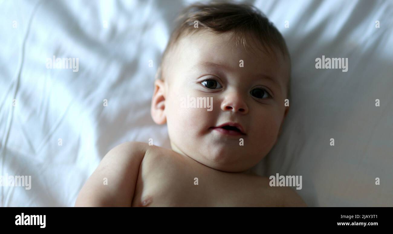 Happy cute baby infant toddler lying in bed smiling Stock Photo Alamy