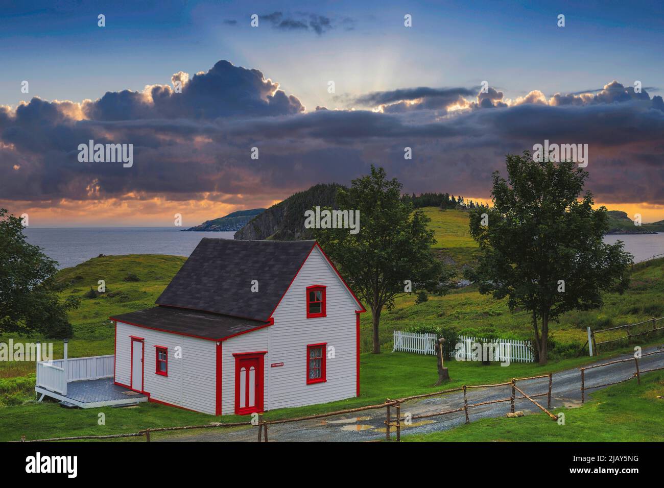 Beautiful white and red cottage in Tors Cove during sunset Newfoundland