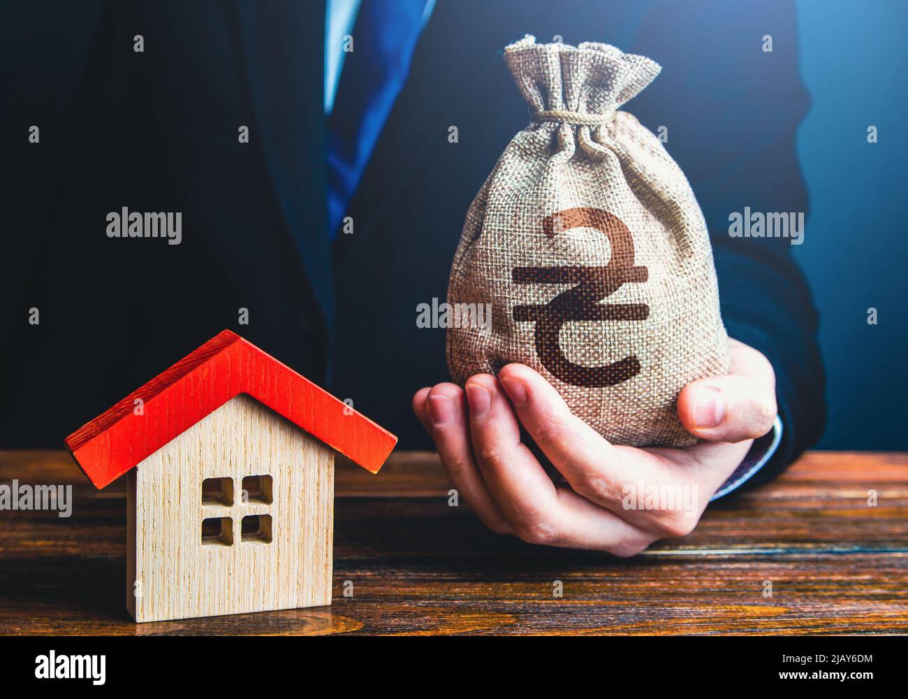 A businessman offers a loan to buy a house. Grants and financial assistance to rebuild and buy a home. Bank approval of a mortgage. Invest in real est Stock Photo