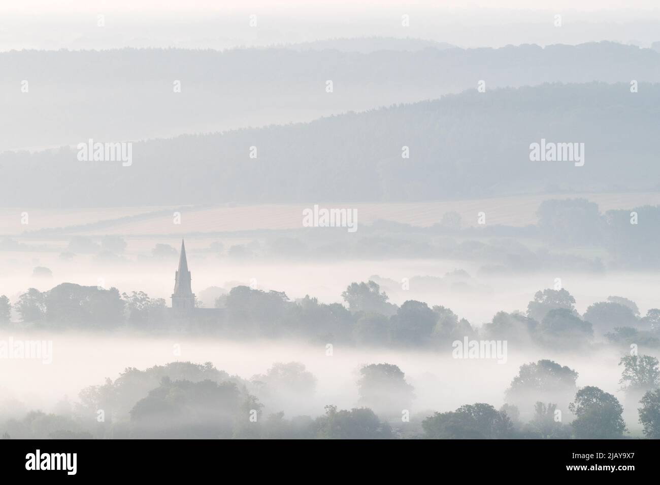St Barnabas Church in Weeton is prominient above the mist drifting across Arthington Pastures on a late summer morning. Stock Photo