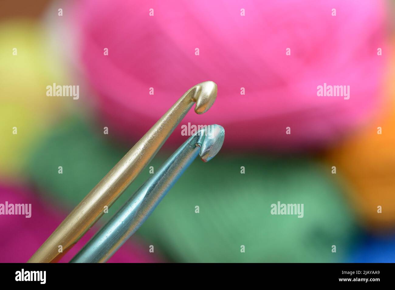 two crochet hooks on a background of colorful wool Stock Photo