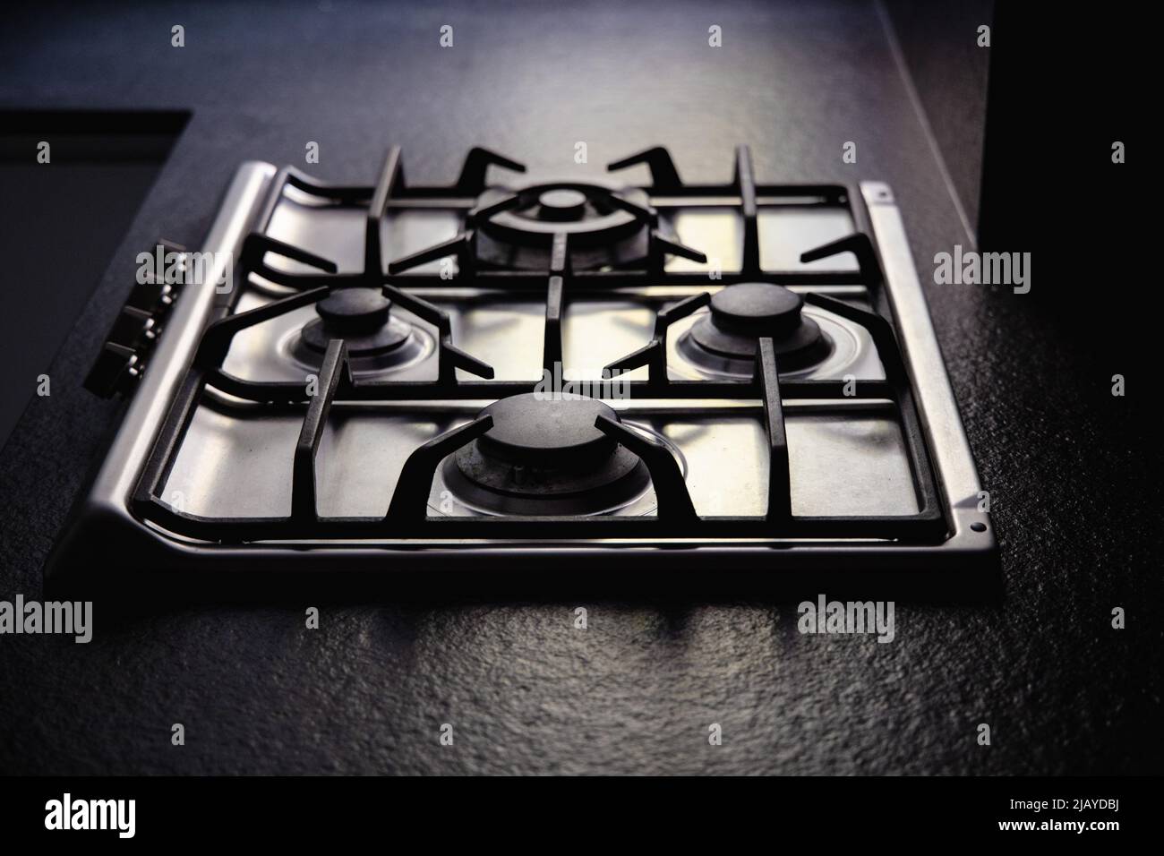 Modern steel gas stove built into a black worktop, gas bills, rise in