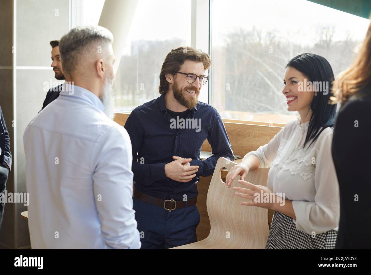 Business colleagues having fun chatting and discussing work in casual conversation in office. Stock Photo