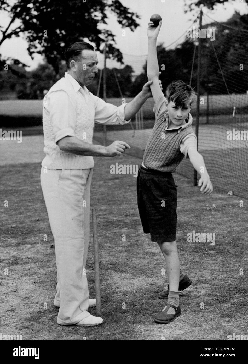 His Royal Pupil -- Mr. Ernie Webster, seen instructing his Royal pupil in the art of bowling, during one of 12-year-old Prince Williams regular Cricket lessons at Broadstairs. Ernie Webster, well-known in Kent as a cricket and soccer Coach, has a Prince among his pupils - William of Gloucester, With his younger brother, Prince Richard, the 12-year-old son of the Duke and Duchess of Gloucester, is being educated at Wellesley House School, Broadstairs and every week he is among the private pupils of Mr. Webster, a former Lenos and British Empire Cricketer. June 10, 1954. (Photo by Fox Photos). Stock Photo