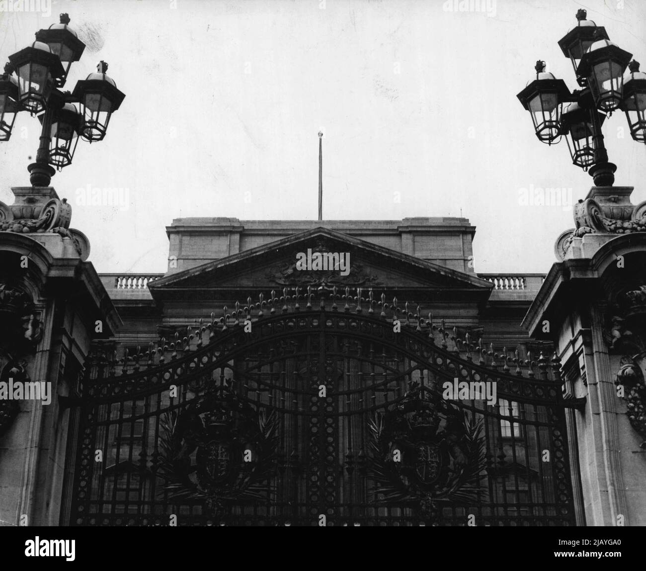 Round And About Buckingham Palace - The central or main gates to Buckingham Palace. Adorned with the Royal crest, the gates are flanked by pillars which are topped with 'bunch-Of-grapes' clusters of lanterns. Seen above the gates, at the triangular upper finish of the Palace centre, the Royal coat-of-arms is seen again. January 11, 1949. (Photo by Camera Press). Stock Photo