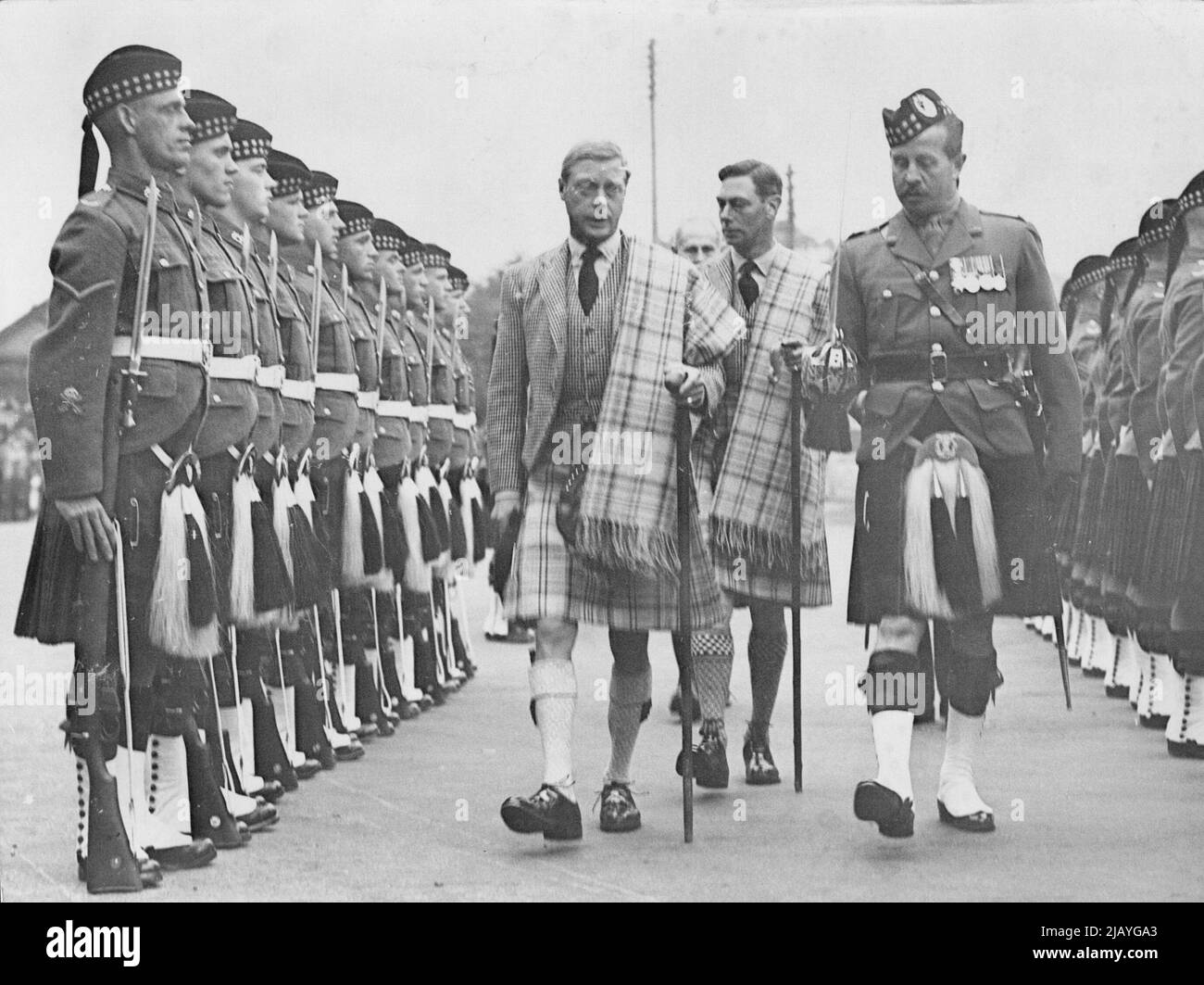 The King in Scotland: The King with the Duke of York inspecting the first Gordon Highlanders when he arrived at Ballater, Scotland, where he is continuing his holiday. The King and the Duke are seen wearing the Balmoral Kilt and Plaid. September 20, 1936. (Photo by Topical Press). Stock Photo