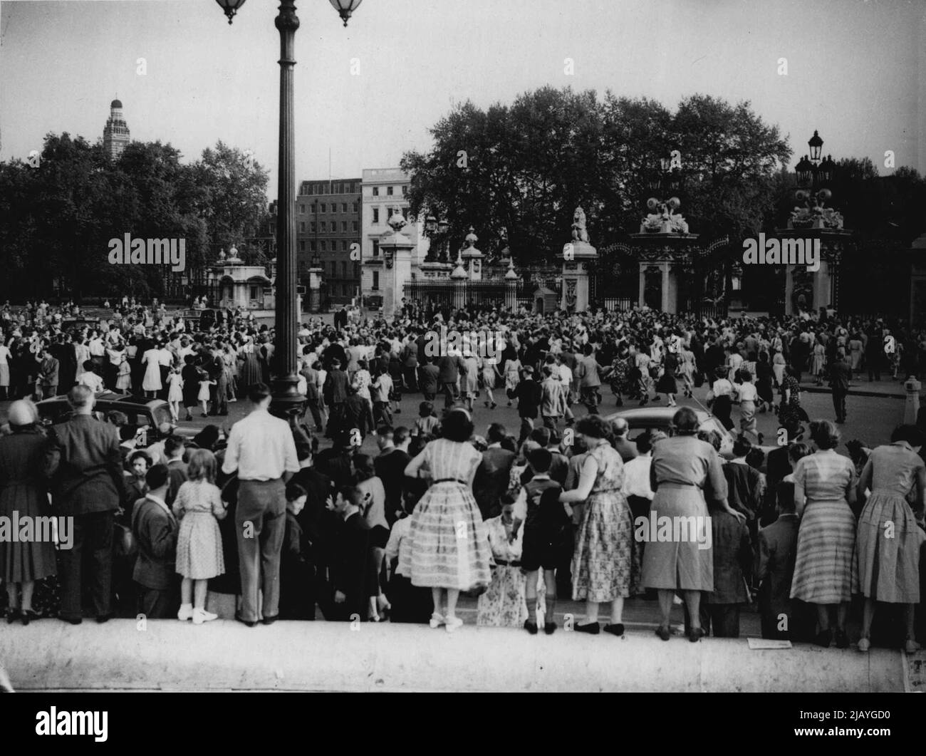 London is packed by sightseers up to see the coronation decorations. This crowd of people were standing quietly outside Buckingham Palace, when all of a sudden the rumour went round that the Queen was returning from Windsor, and as can be seen in the picture there was a sudden rush towards the Palace gates. May 25, 1953. (Photo by Daily Mail Contract Pictures). Stock Photo