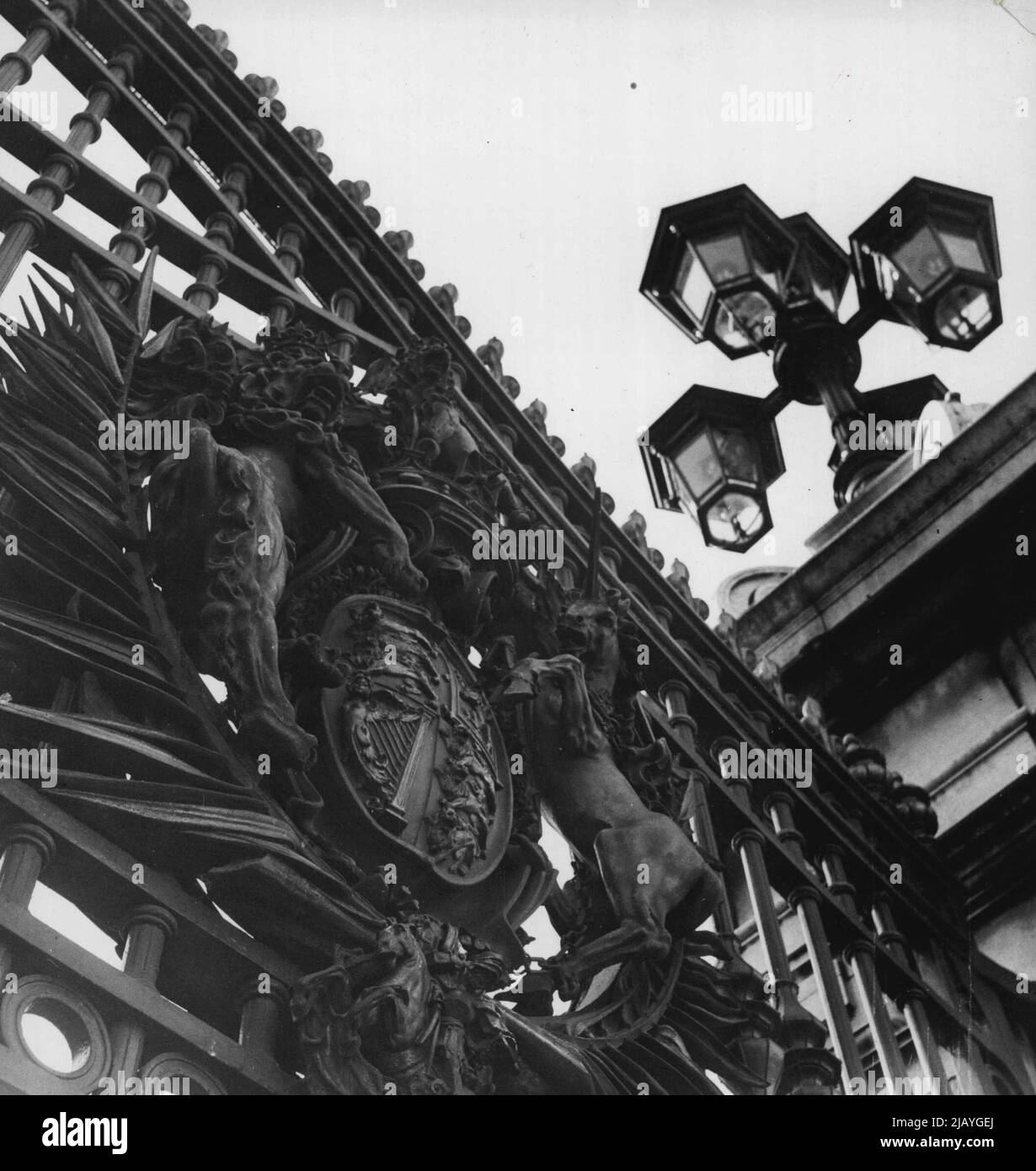 Round And About Buckingham Palace - Royal crest on gates and one of the 'bunch-of-grapes' clusters of lanterns. January 11, 1949. (Photo by Camera Press). Stock Photo