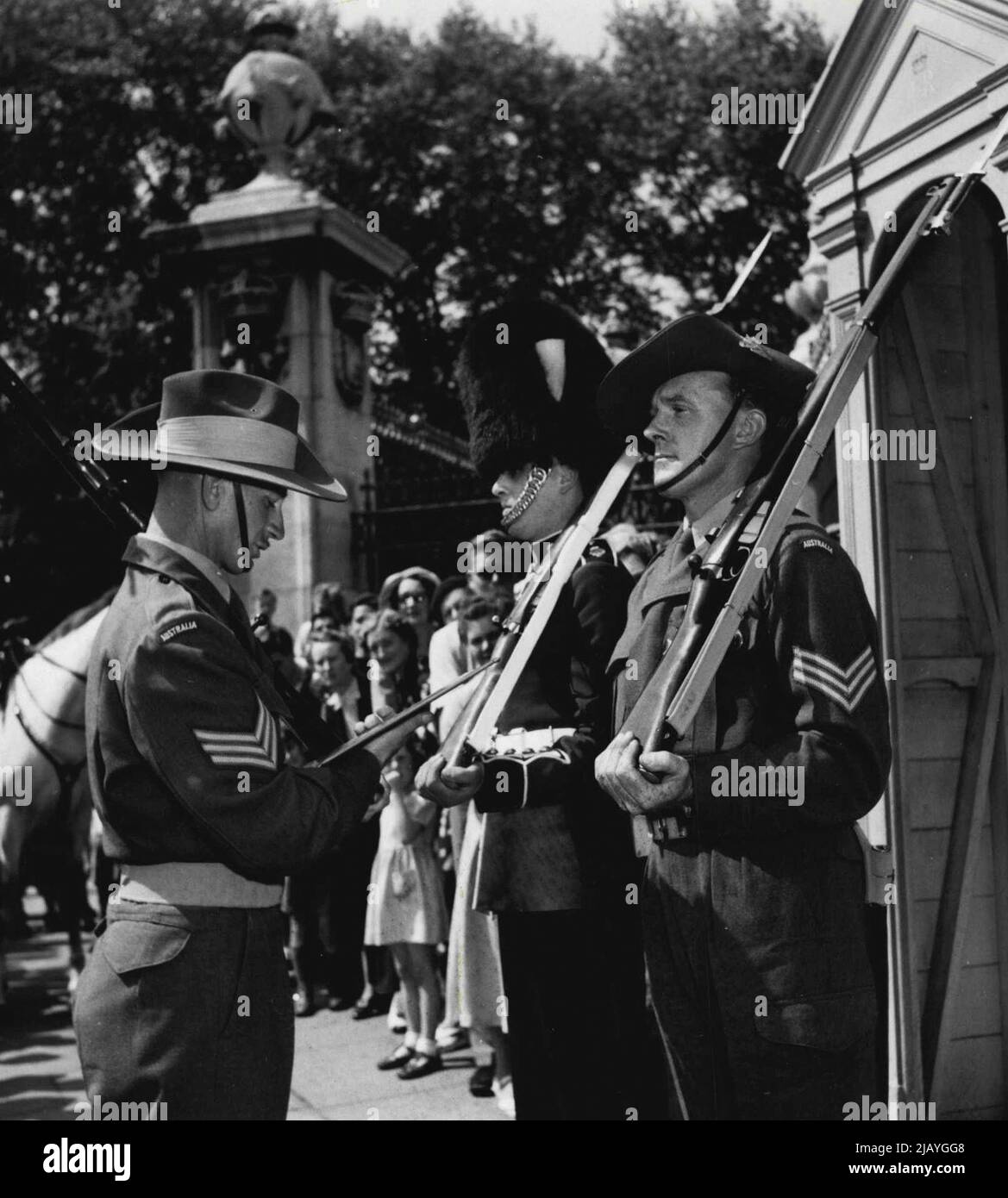 The Australian sergeant reading the take-over orders to an Australian sentry. Changing Guards at Buckingham Palace - but with a difference. The Australian Coronation contingent marched into Buckingham Palace today and took over guard duty from the Grendadiers. May 26, 1953. (Photo by Daily Mirror). Stock Photo