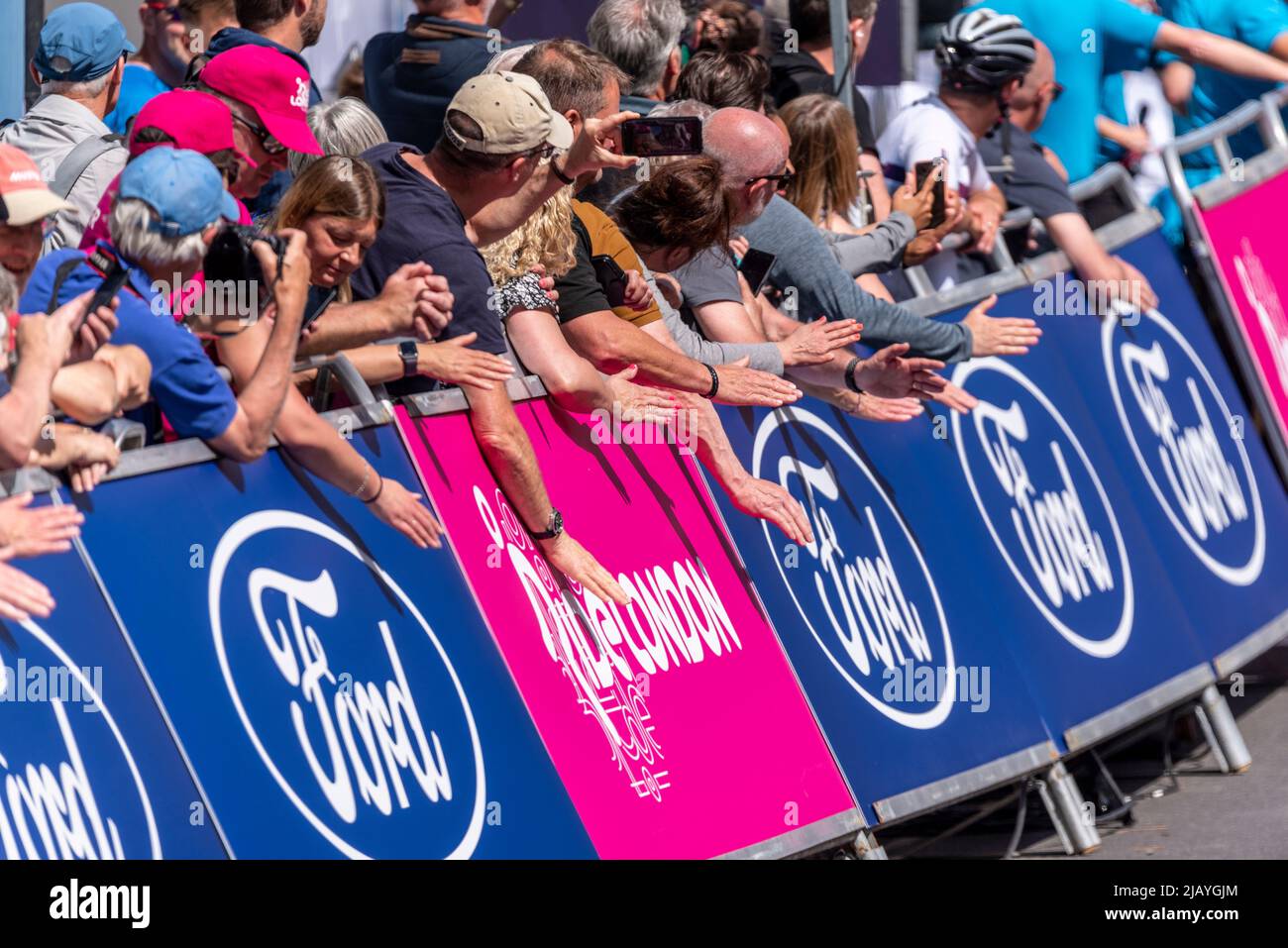 Crowds at the finish line at the RideLondon Classique cycle race stage 1, at Maldon, Essex, UK, banging the advertising boards to inspire riders Stock Photo