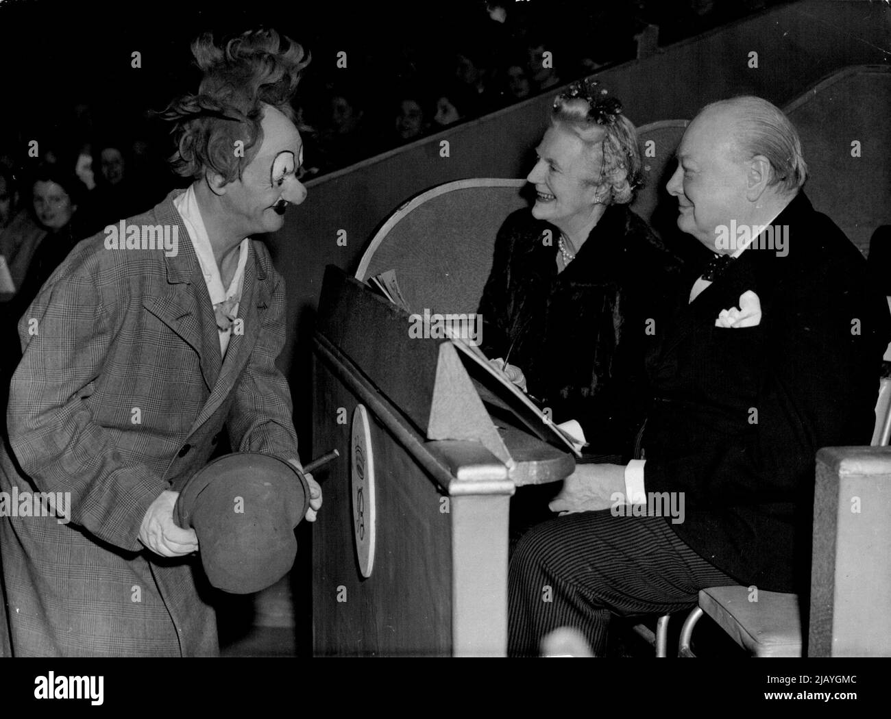 Funny Business For The Churchills : Mr. and Mrs. Winston Churchill enjoy a joke with Coco, a clown in Bertram Mills circus, at Olympia, London last night, December 20. The circus is one of London's big Christmas events, and one of Santa Claus most coveted gifts is a ticket to the show. December 21, 1948. (Photo by Associated Press Photo). Stock Photo